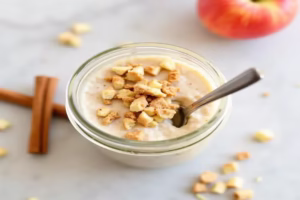 Apple Cinnamon Overnight Oats served in a mason jar with a spoon and a sprinkle of crisp topping.